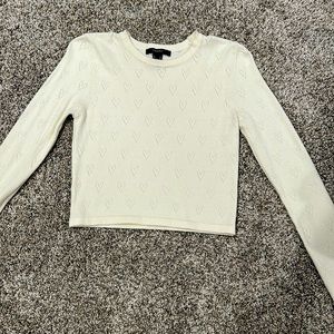 Cute sweater with small holes shaping into heart formation, white, slight crop.